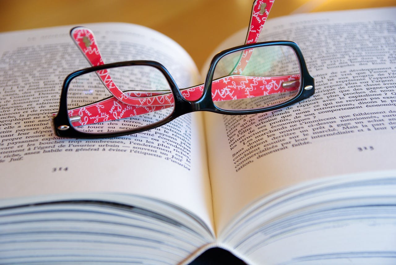 Black Framed Eyeglasses on Book Page